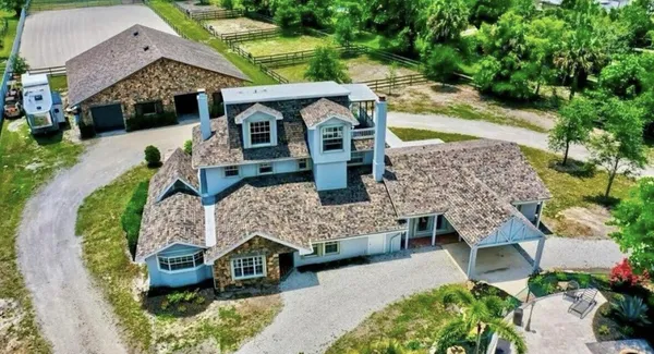 an aerial view of a house with a yard basket ball court and outdoor seating