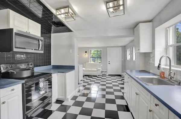 a kitchen with a sink a stove and cabinets