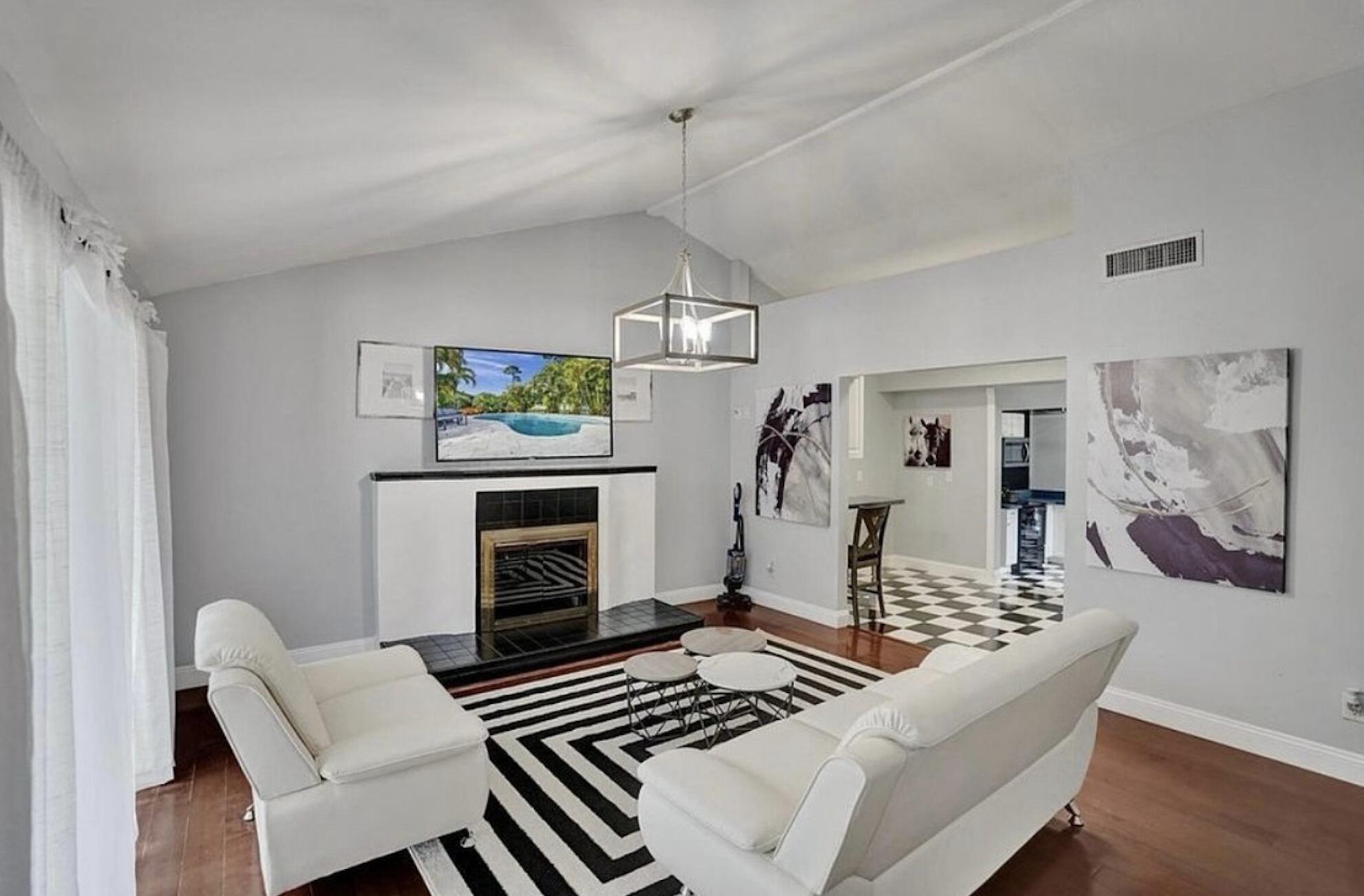 502 Rambling Dr Circle, Unit #2 Wellington, FL 33414 - Photo 6 of 18 a living room with furniture a fireplace and a chandelier