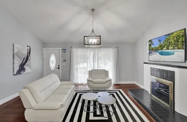 a living room with furniture a fireplace and a chandelier