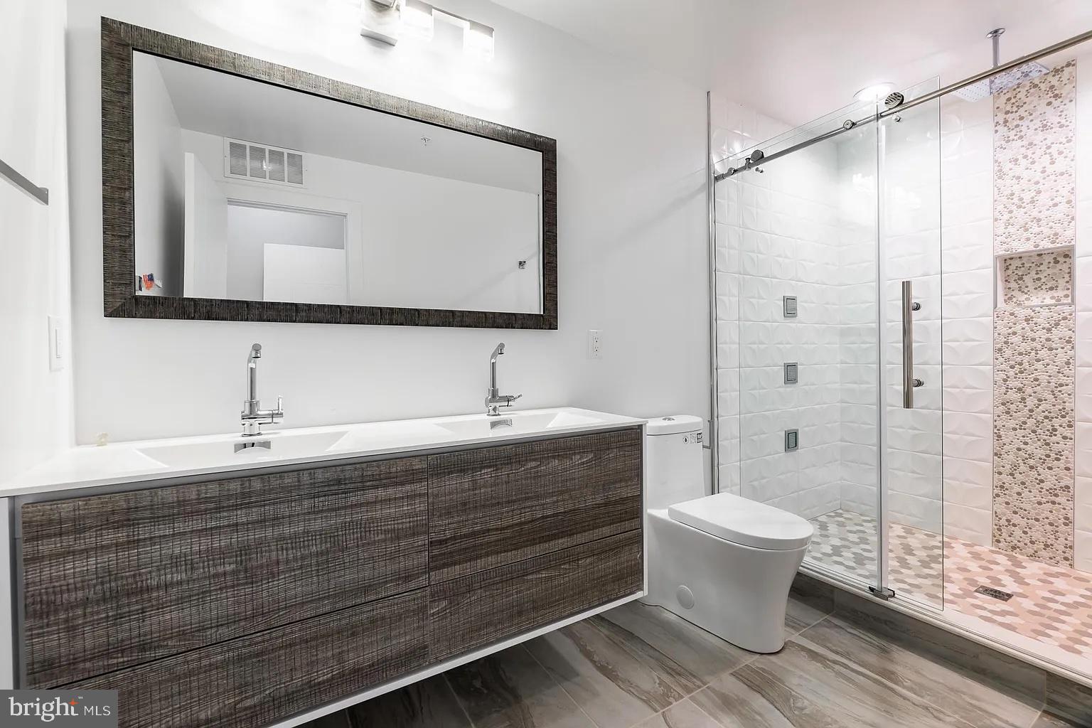 2055 Tasker Street Philadelphia, PA 19145 - Photo 30 of 40 a bathroom with a sink toilet a mirror and shower