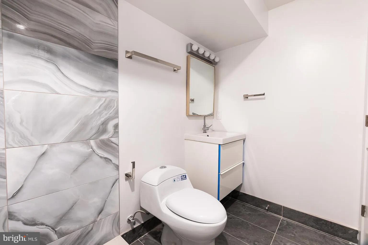 2055 Tasker Street Philadelphia, PA 19145 - Photo 39 of 40 a bathroom with a toilet sink and vanity