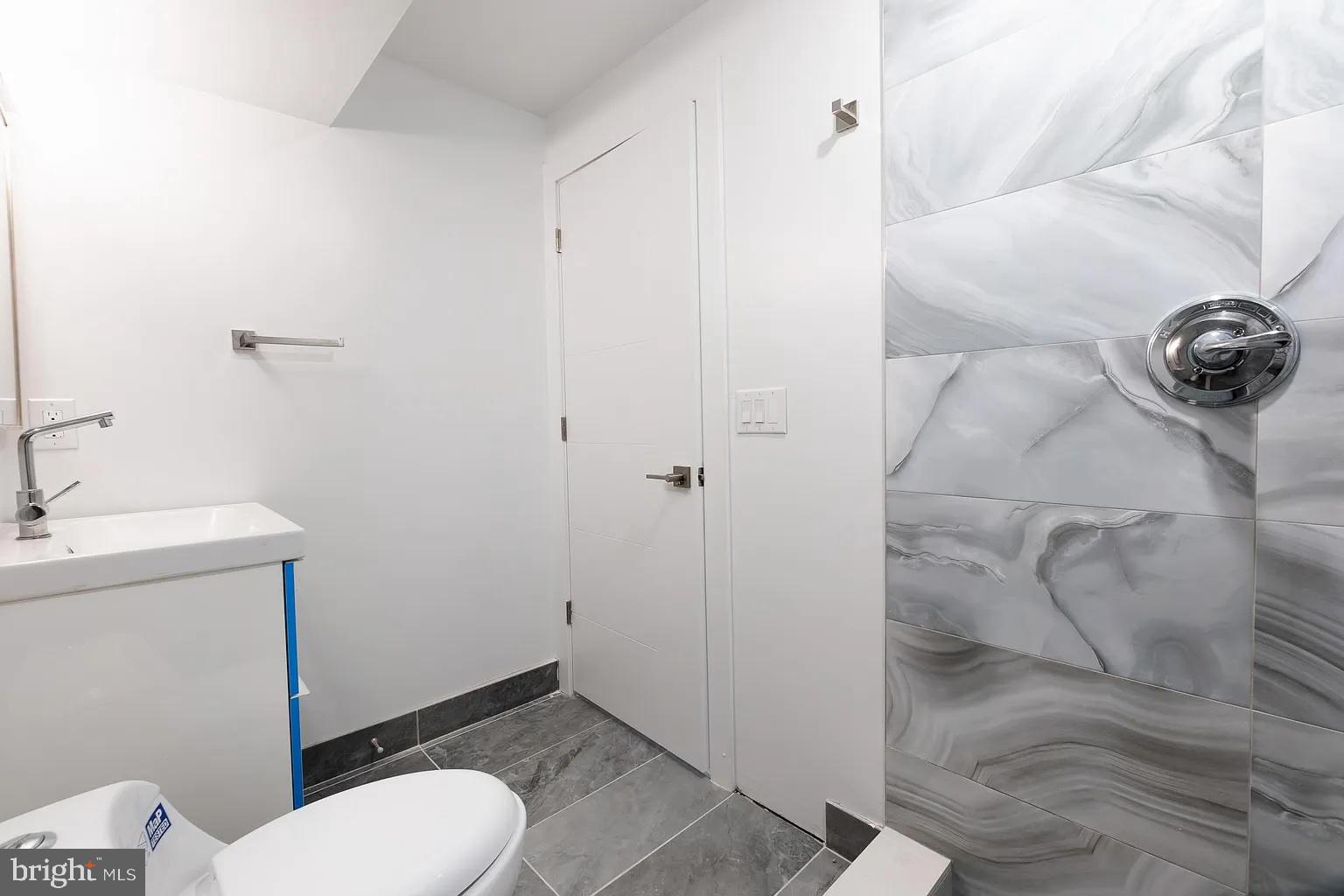 2055 Tasker Street Philadelphia, PA 19145 - Photo 40 of 40 a bathroom with a granite countertop toilet and a sink