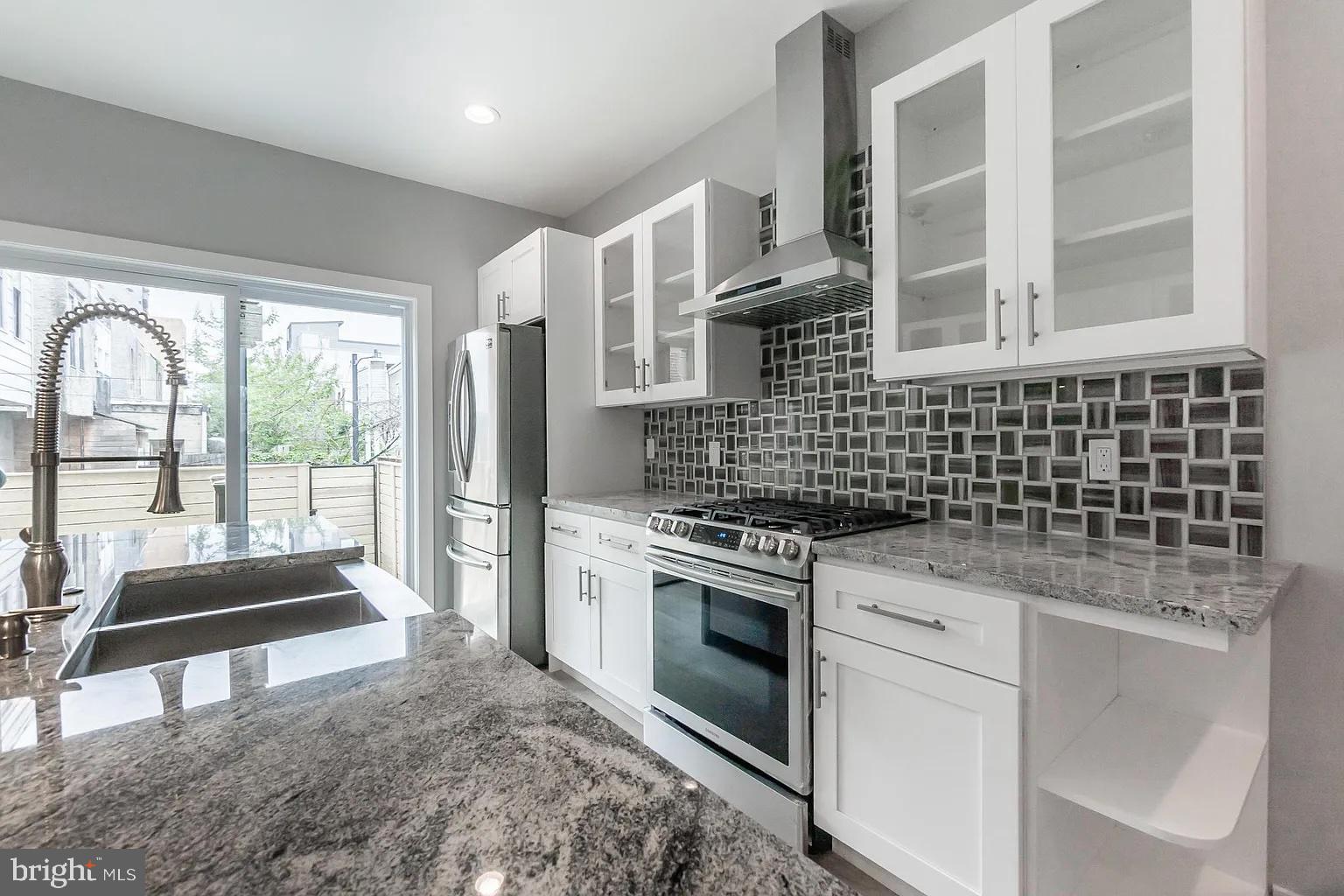 2055 Tasker Street Philadelphia, PA 19145 - Photo 7 of 40 a kitchen with a stove a sink and a refrigerator