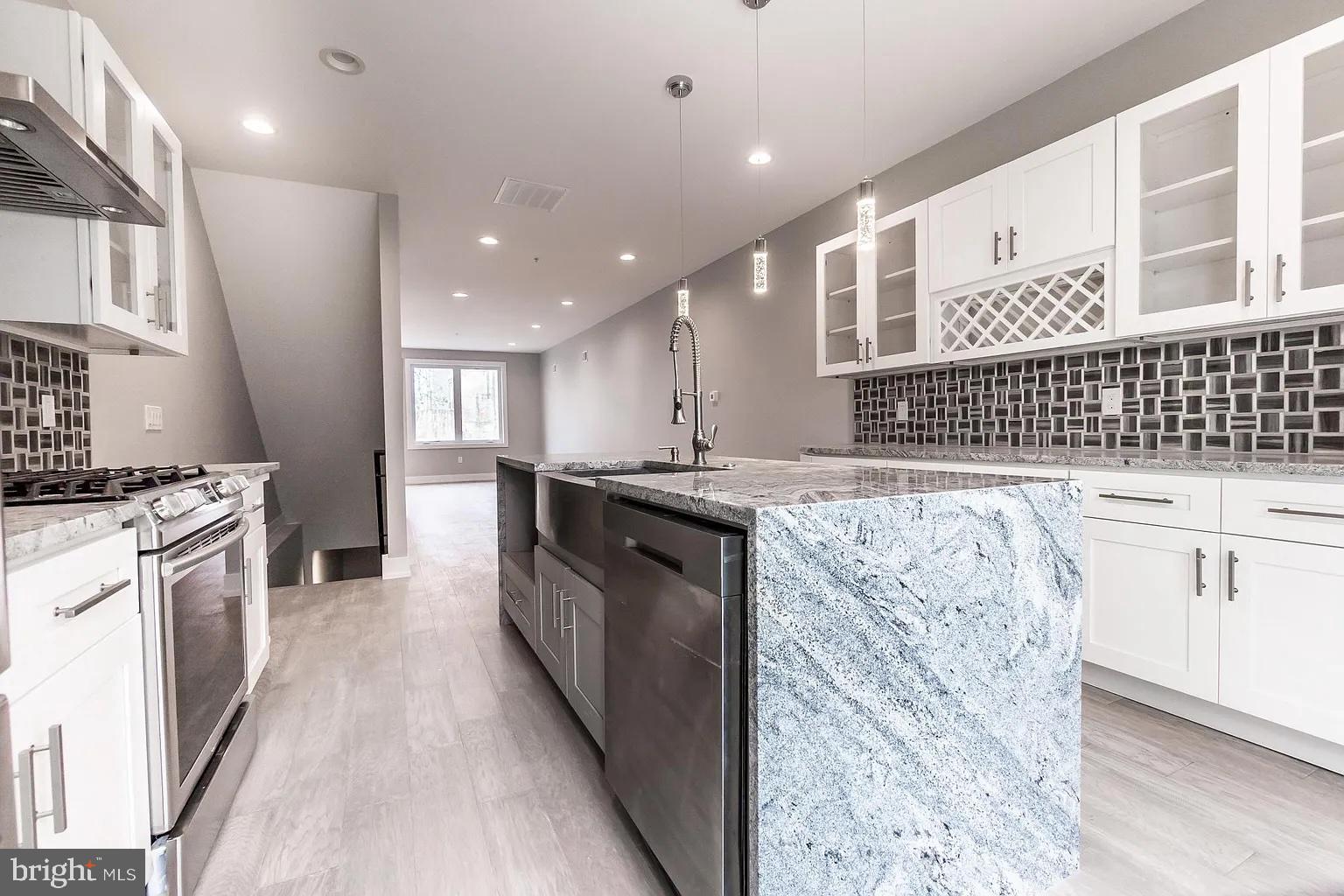 2055 Tasker Street Philadelphia, PA 19145 - Photo 9 of 40 a kitchen with stainless steel appliances kitchen island granite countertop a stove a sink and a refrigerator