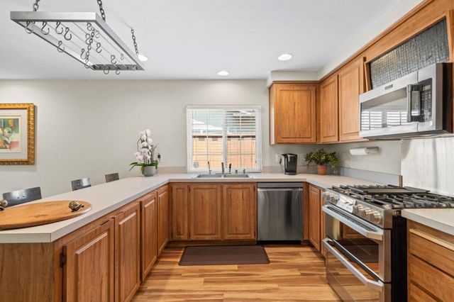 a kitchen with stainless steel appliances granite countertop a sink and stove