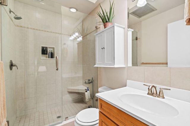 a bathroom with a sink a toilet a mirror and shower