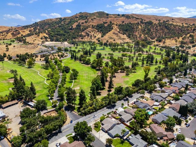 an aerial view of residential houses with outdoor space and trees