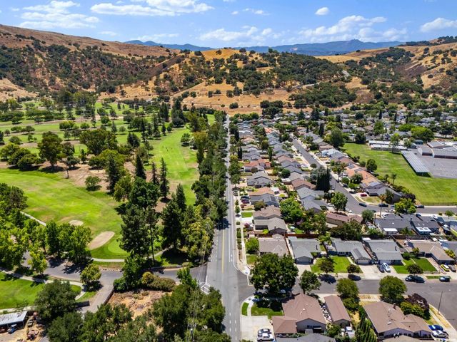 an aerial view of residential houses with outdoor space and trees