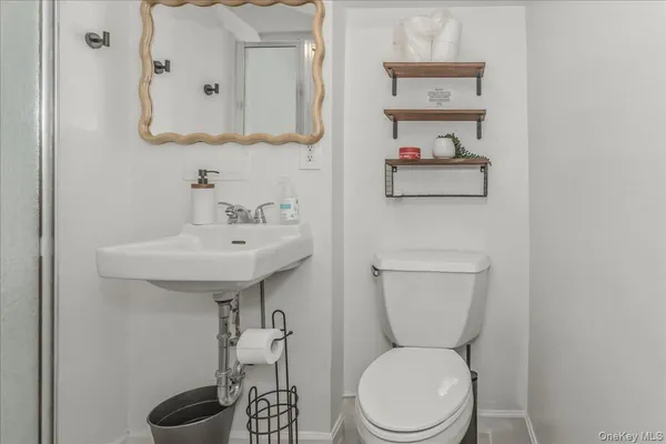 a bathroom with a toilet a sink and mirror