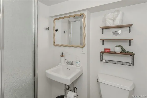 a bathroom with a sink a toilet and a mirror