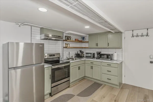 a kitchen with stainless steel appliances granite countertop a refrigerator and a stove top oven