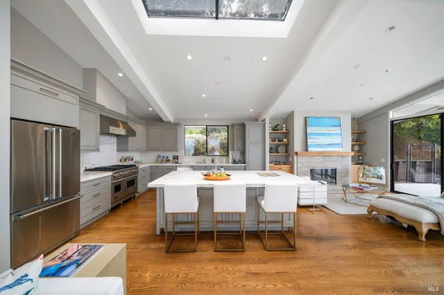 a large dining hall with stainless steel appliances granite countertop a couch dining table and chairs