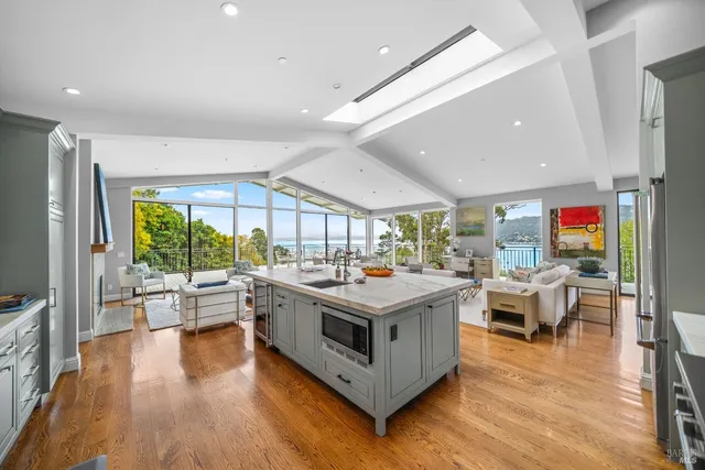 a living room with stainless steel appliances granite countertop a stove and wooden floor