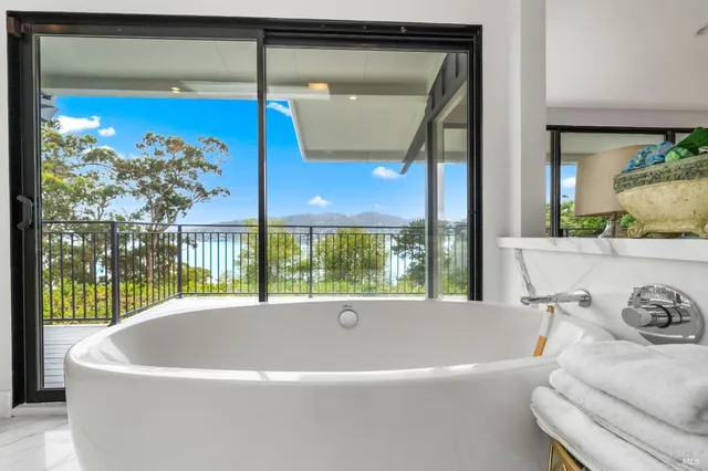 a white bath tub sitting in a bathroom next to a window