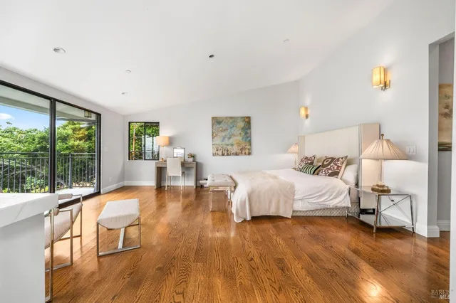 a spacious bedroom with a large bed and a wooden floor