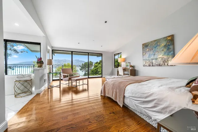 a bedroom with a large bed a flat tv screen and a table