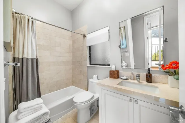 a bathroom with a sink a toilet a mirror and shower