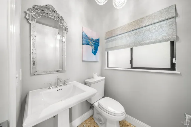 a bathroom with a toilet a sink and mirror