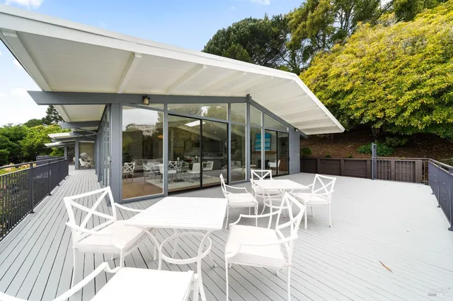 a view of a patio with a dining table and chairs with wooden floor