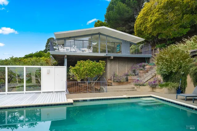 a view of a house with backyard and sitting area