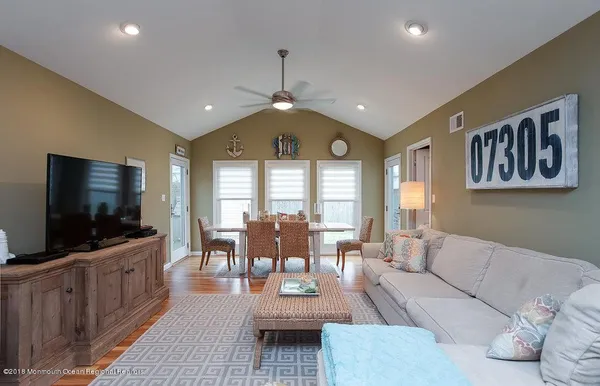 a living room with furniture a wooden floor and chandelier