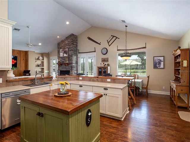 a kitchen with a sink appliances and wooden floor