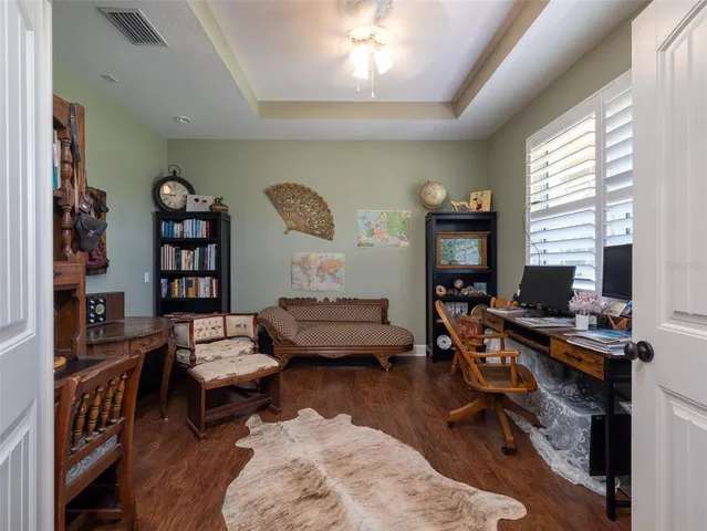 a living room with furniture a bookshelf and a window