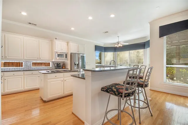 a kitchen with stainless steel appliances a table and chairs in it