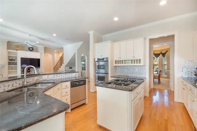a kitchen with stainless steel appliances granite countertop a sink stove and refrigerator