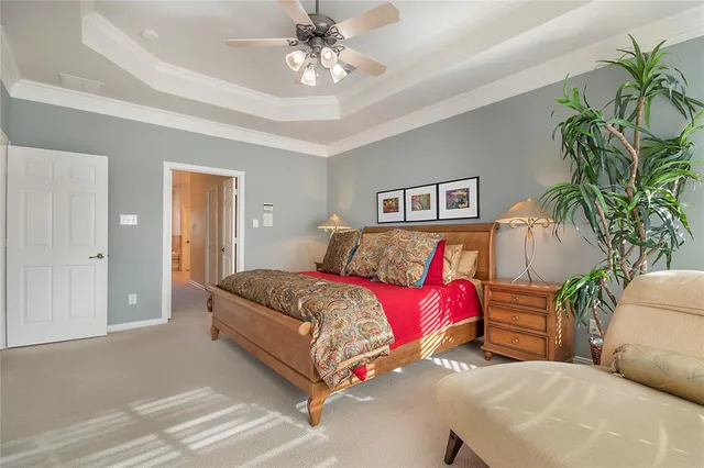 a bedroom with a large bed and a chandelier