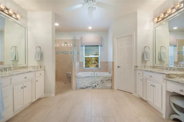 a spacious bathroom with a granite countertop sink a toilet a shower and a mirror