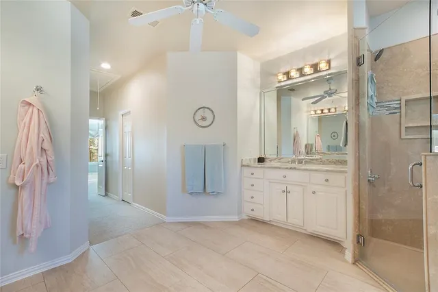 a spacious bathroom with a granite countertop sink a mirror and a shower