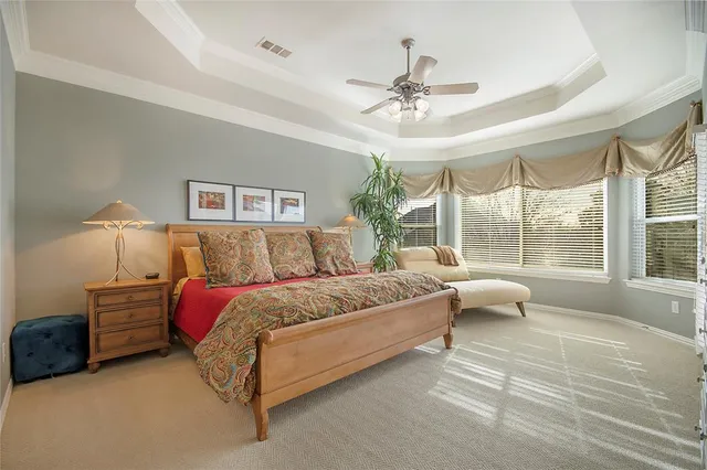 a spacious bedroom with a bed couch and window