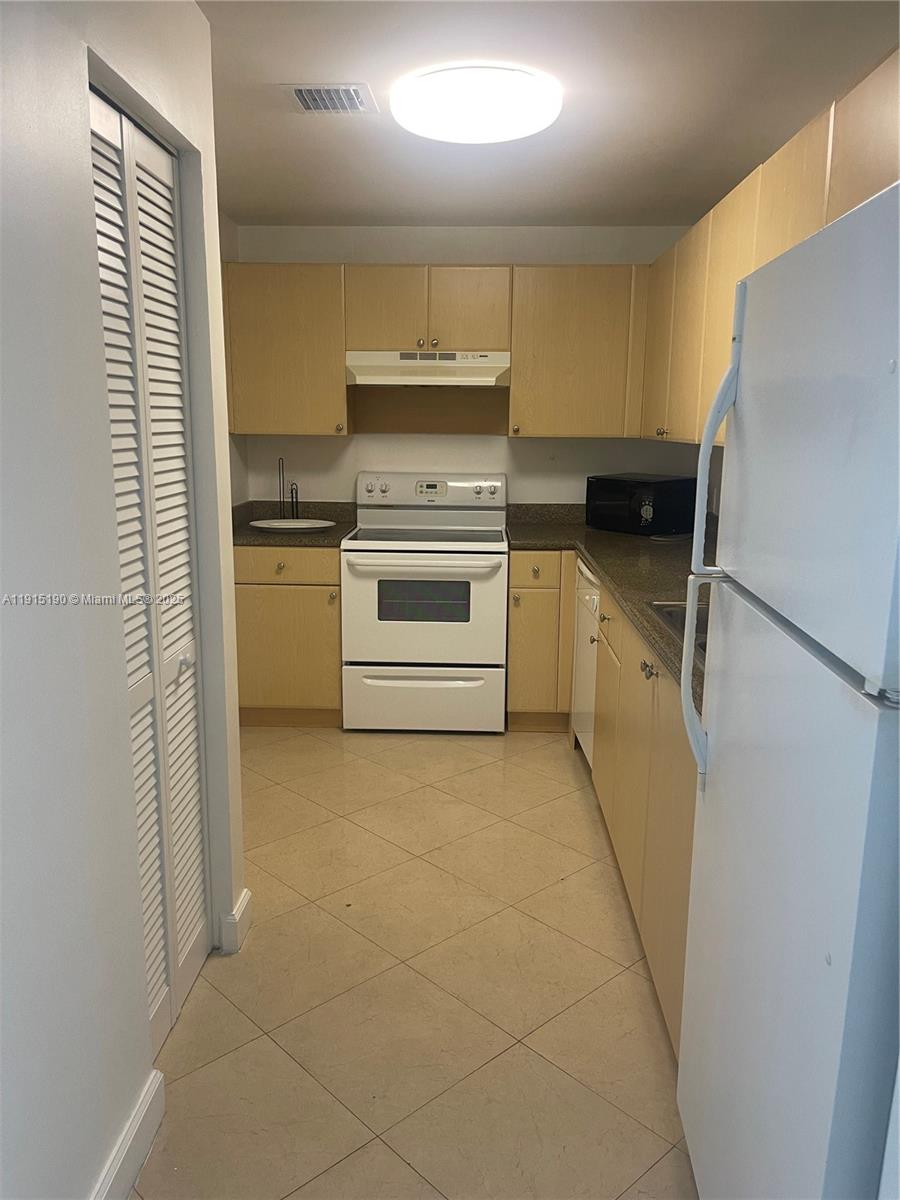 2280 Southwest 32nd Avenue, Unit 410 Miami, FL 33145 - Photo 2 of 6 a kitchen with a refrigerator and a stove top oven