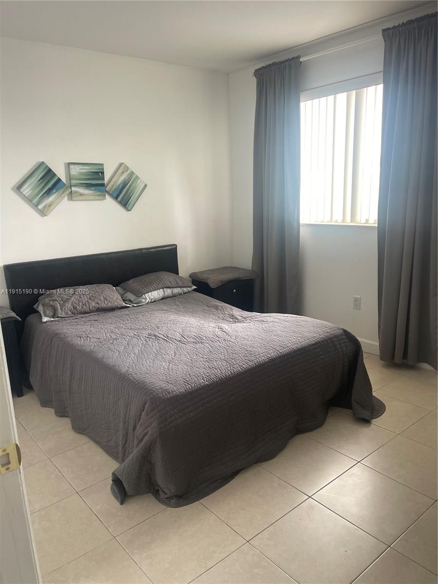 2280 Southwest 32nd Avenue, Unit 410 Miami, FL 33145 - Photo 4 of 6 a bedroom with a bed and window