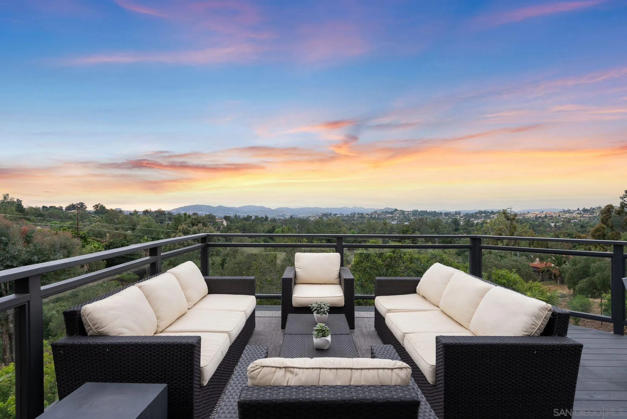 a view of a roof deck with couches and sky view