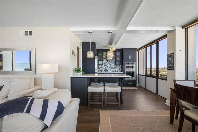 a kitchen with a refrigerator a dining table and chairs