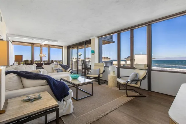 a living room with furniture floor to ceiling window and a flat screen tv