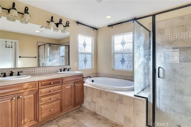 a spacious bathroom with a tub sink shower and mirror