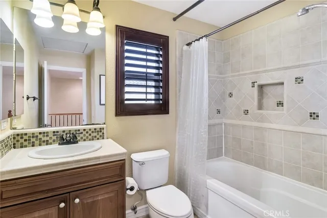 a bathroom with a granite countertop sink toilet a large mirror a shower and a bathtub