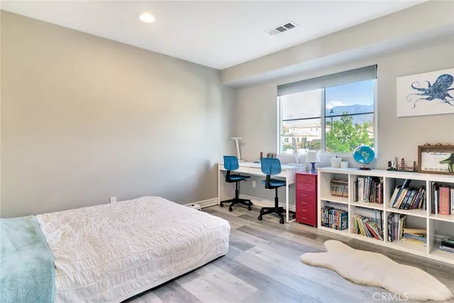 a bedroom with a bed a large window and a book shelf