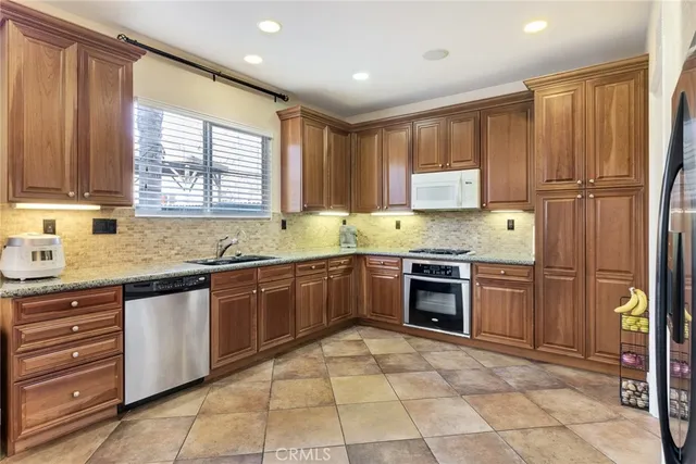 a kitchen with stainless steel appliances granite countertop a stove sink and cabinets
