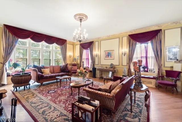 a living room with furniture chandelier and a large window
