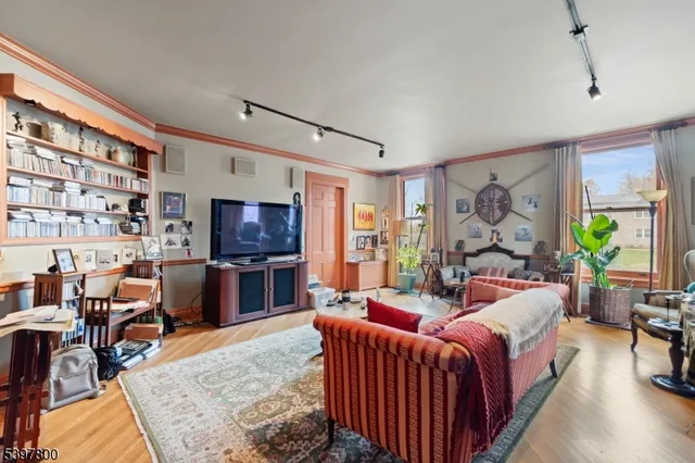 a living room with furniture a flat screen tv and a floor to ceiling window