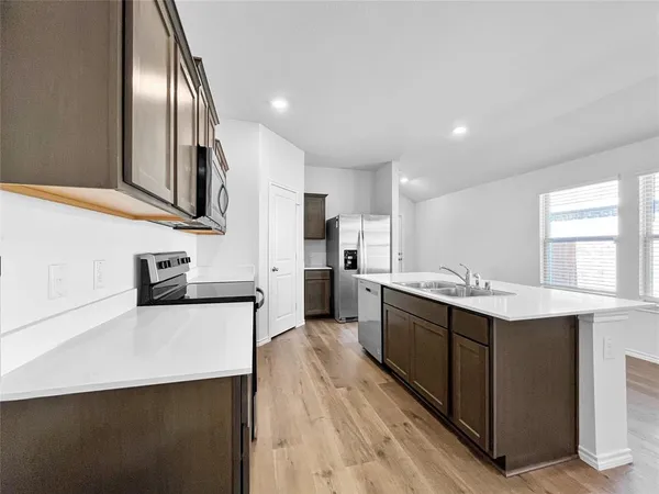 a kitchen with stainless steel appliances a sink stove and refrigerator