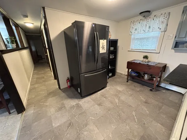 a view of a livingroom with furniture and a refrigerator