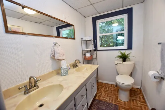 a bathroom with a toilet sink and mirror