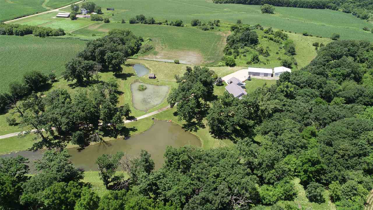 6652 North Cedar Road Forreston, IL 61030 - Photo 2 of 25 an aerial view of green landscape with trees houses and lake view