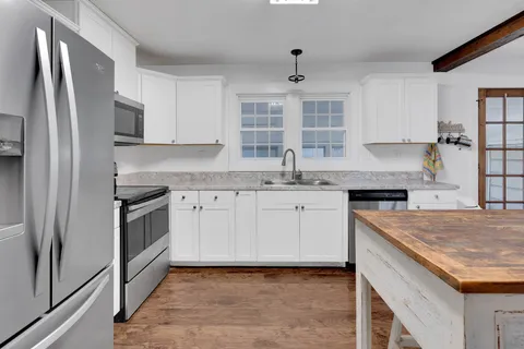 a kitchen with granite countertop a sink stainless steel appliances and counter space